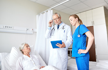 Image showing doctor and nurse visiting senior woman at hospital