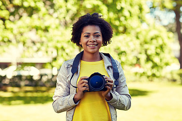Image showing happy african woman with digital camera in park