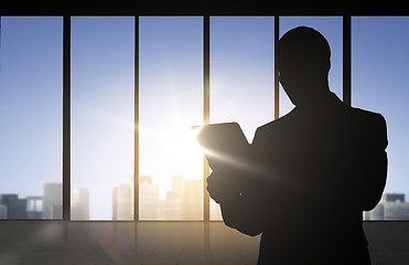 Image showing silhouette of businessman with tablet pc at office