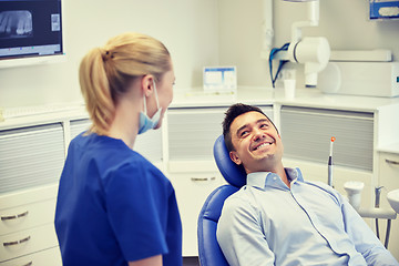 Image showing happy female dentist with man patient at clinic