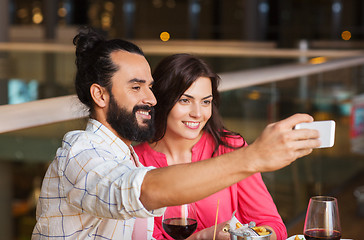 Image showing couple taking selfie by smartphone at restaurant