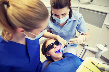 Image showing female dentists treating patient girl teeth