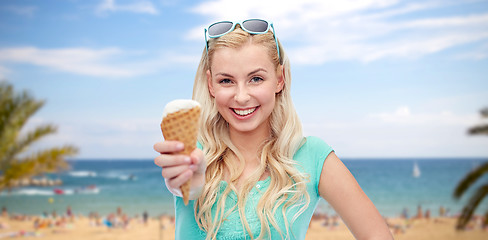 Image showing happy young woman in sunglasses eating ice cream