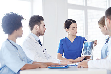 Image showing group of doctors with x-ray on tablet pc at clinic