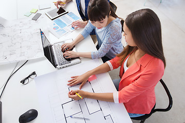 Image showing creative team with laptop and blueprint at office