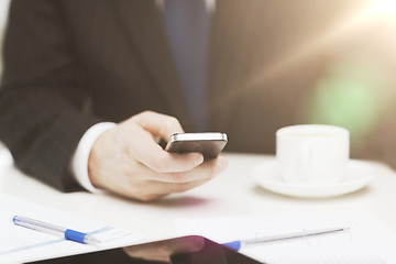 Image showing businessman with smartphone reading news