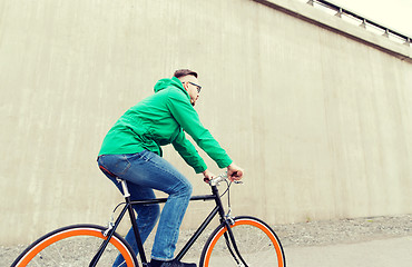 Image showing happy young hipster man riding fixed gear bike