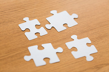 Image showing close up of puzzle pieces on wooden surface