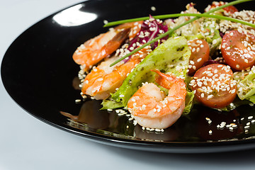 Image showing perfect dish with shrimps on a black plate. seafood