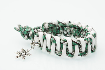 Image showing green braided bracelet on white background. snowflake