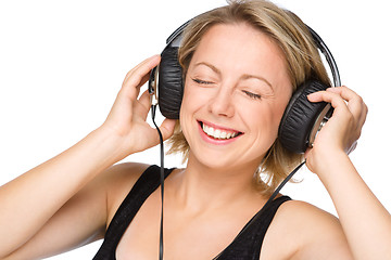 Image showing Young woman enjoying music using headphones