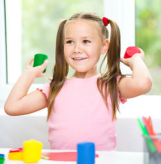 Image showing Little girl is playing with plasticine