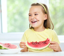 Image showing Cute little girl is eating watermelon