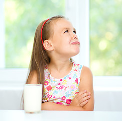 Image showing Sad little girl with a glass of milk