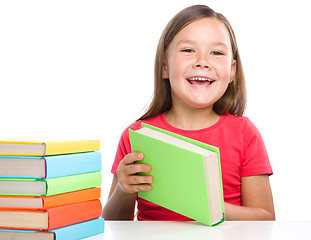 Image showing Little girl is reading a book