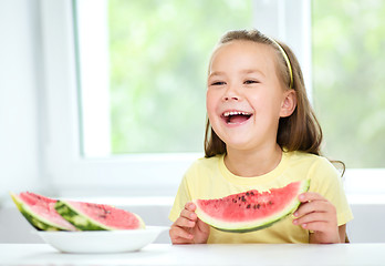 Image showing Cute little girl is eating watermelon