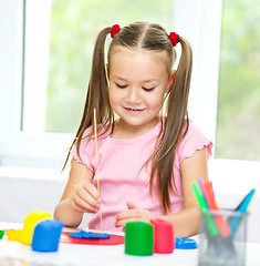 Image showing Little girl is playing with plasticine