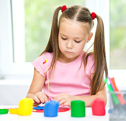 Image showing Little girl is playing with plasticine