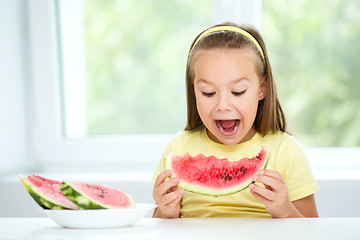 Image showing Cute little girl is eating watermelon