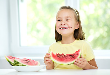 Image showing Cute little girl is eating watermelon