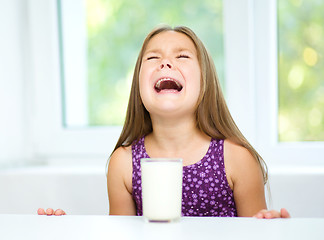 Image showing Sad little girl with a glass of milk