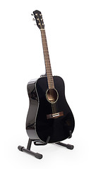 Image showing Black acoustic guitar on stand, isolated