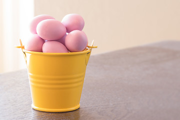 Image showing Yellow bucket with violet easter eggs