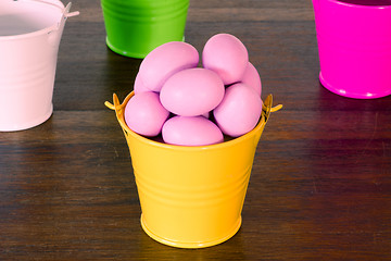 Image showing Violet easter eggs in a yellow bucket