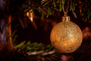 Image showing Golden Xmas bauble hanging on a tree