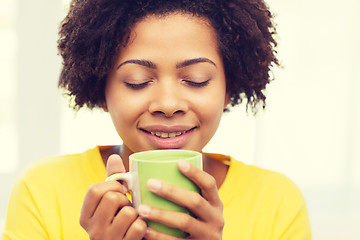 Image showing happy african american woman drinking from tea cup