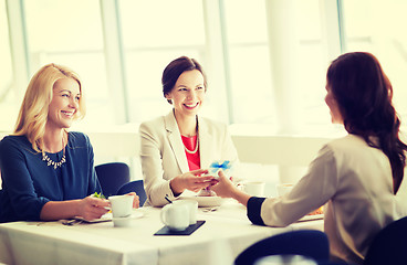 Image showing happy women giving birthday present at restaurant