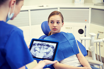 Image showing dentist showing x-ray on tablet pc to patient girl