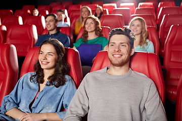 Image showing happy friends watching movie in theater