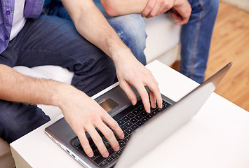 Image showing close up of male friends with laptop at home