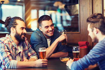 Image showing happy male friends drinking beer at bar or pub