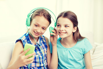 Image showing happy girls with smartphone and headphones