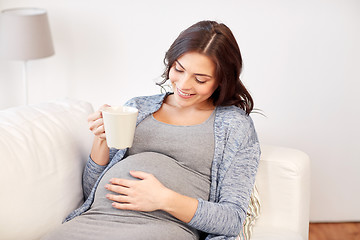 Image showing happy pregnant woman with cup drinking tea at home