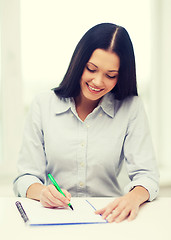 Image showing smiling businesswoman or student studying