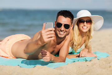 Image showing happy couple in swimwear walking on summer beach