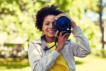 Image showing happy african woman with digital camera in park