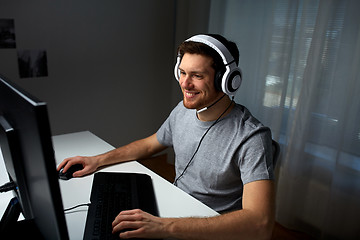 Image showing man in headset playing computer video game at home