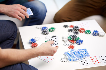 Image showing close up of male friends playing cards at home