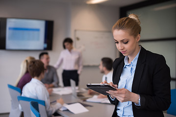 Image showing business woman working on tablet at meeting room