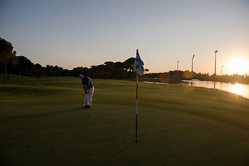 Image showing golfer hitting ball to hole