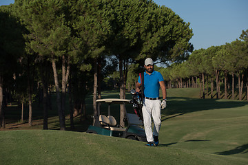 Image showing golfer  walking and carrying golf  bag