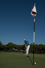 Image showing golf player hitting shot at sunny day