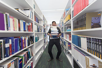 Image showing Student holding lot of books in school library