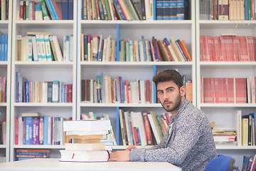 Image showing portrait of student while reading book  in school library