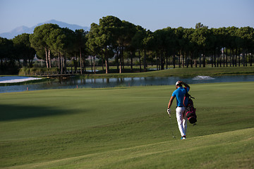 Image showing golfer  walking and carrying bag