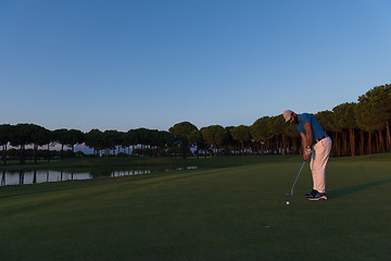 Image showing golfer  hitting shot at golf course